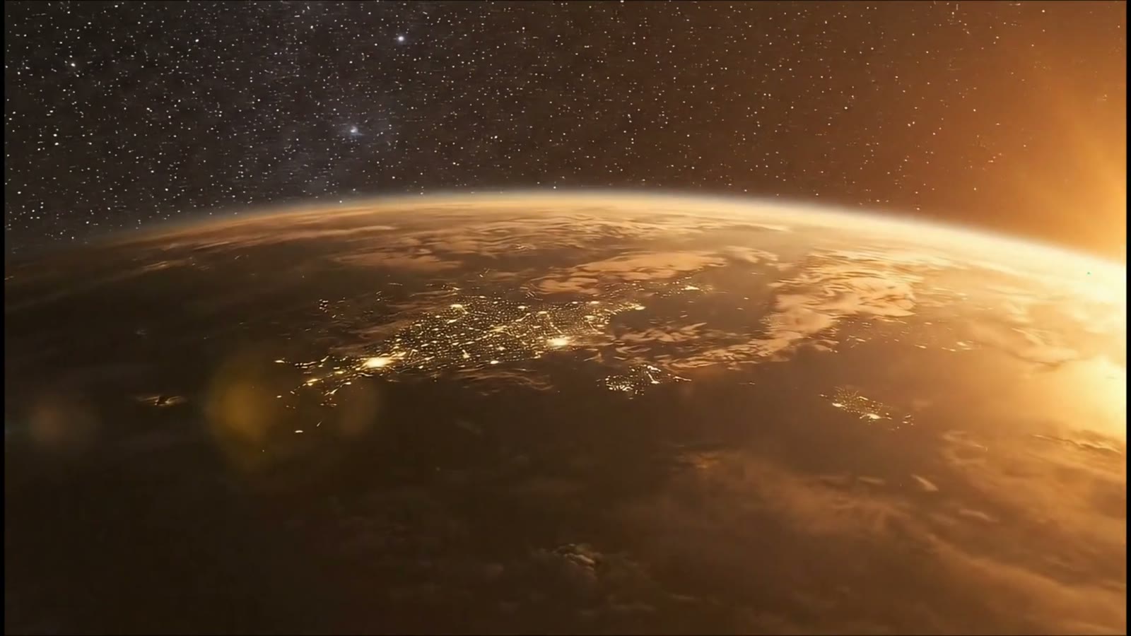 The Earth from orbit at sunrise, cities lit